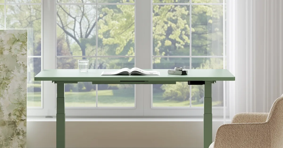 FlexiSpot E7 motorized standing desk positioned in bright home office workspace