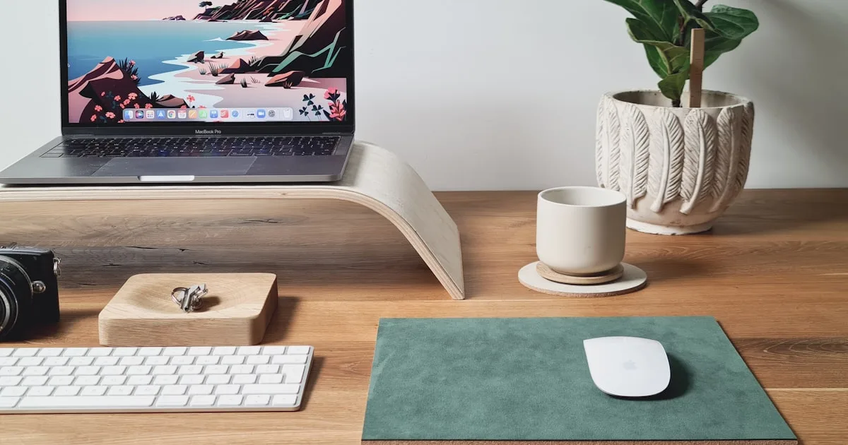 Laptop elevated on a stand at eye level with external keyboard and mouse for proper ergonomic positioning at a home office desk